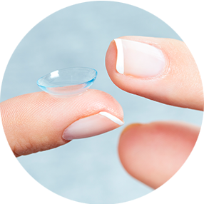 Eine Nahaufnahme von zwei Fingern, die eine weiche, transparente Kontaktlinse halten, mit ordentlich manikürten Nägeln und einem hellblauen Hintergrund.